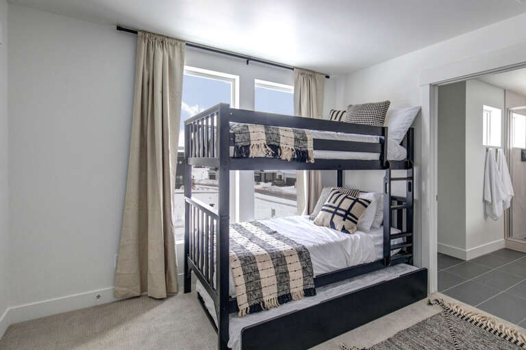 Your kids will love the bunk bed setup in this bright, modern bedroom—perfect for family stays with plenty of natural light streaming in through large windows.