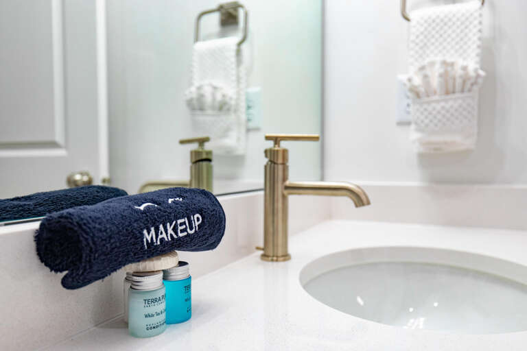 Refresh in your bright, modern bathroom with luxe brass fixtures, a makeup towel, and thoughtfully curated toiletries—a calming space designed for your comfort.