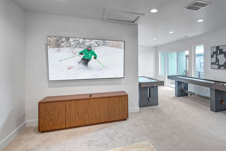 Step into your private game room where you can watch winter sports on the big screen, challenge friends to pool or shuffleboard, and create memories in this modern, light-filled space.