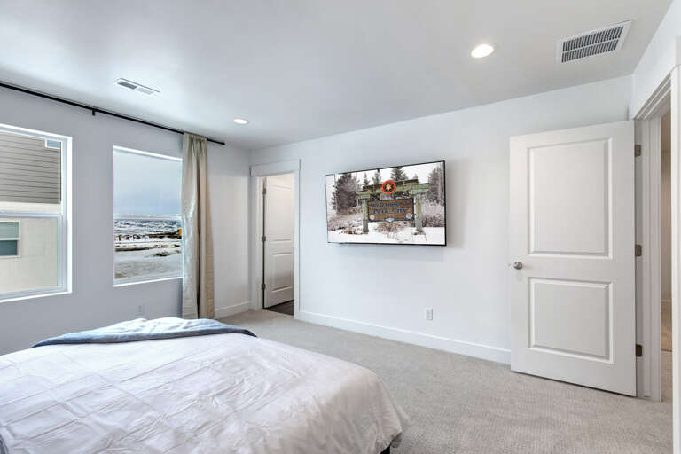 Unwind in your serene bedroom with soft natural light, cozy carpeting, and peaceful mountain views framing your retreat.