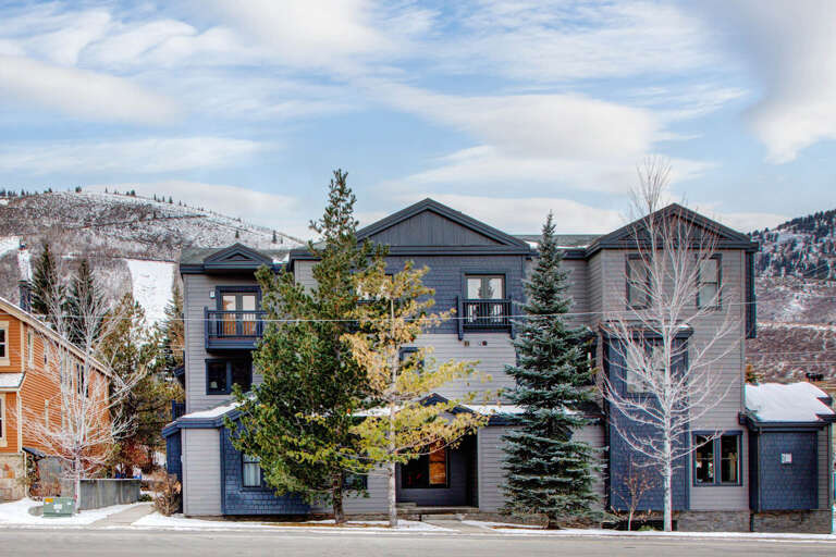 A modern mountain retreat nestled at the base of snow-dusted slopes, perfectly positioned for both adventure and relaxation in a scenic alpine setting.