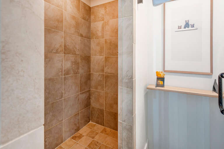 Your private walk-in shower features warm terracotta tile with a rainfall showerhead for a luxurious morning refresh.