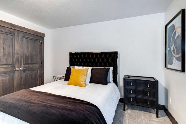 Your restful bedroom awaits with a plush tufted headboard, crisp linens, and elegant touches. Unpack your belongings in the wardrobe and settle into this peaceful retreat designed for your comfort.
