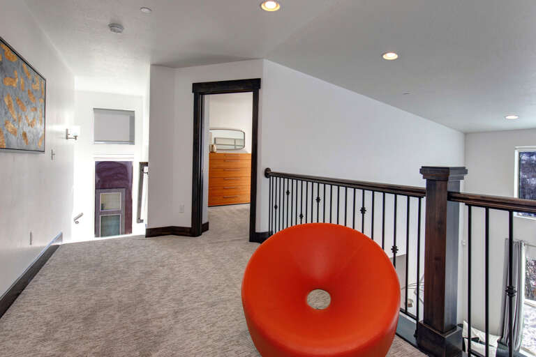 A bright upstairs landing connects you to peaceful sleeping quarters, with a bold statement chair perfect for reading or gazing out at the surrounding views.