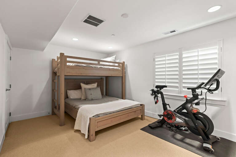 Space for rest and fitness—your private bedroom with bunk bed and a Peloton bike ready for your morning ride.