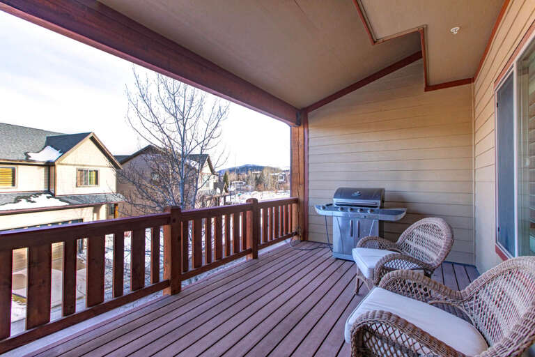 Step onto your private covered balcony and picture crisp mountain mornings with coffee in hand. The gas grill stands ready for sizzling dinners, while cozy wicker chairs invite you to unwind and soak in peaceful neighborhood views.