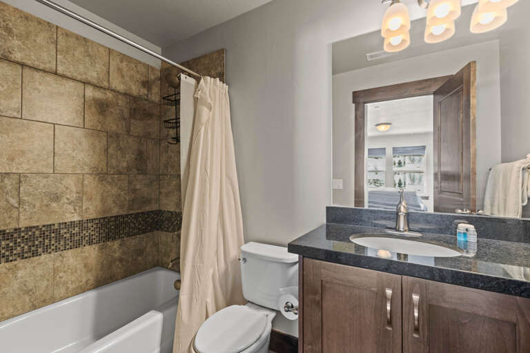 Your beautifully appointed bathroom features elegant tile work, a spacious vanity with modern fixtures, and a relaxing tub-shower combo—perfect for unwinding after a day of adventure.