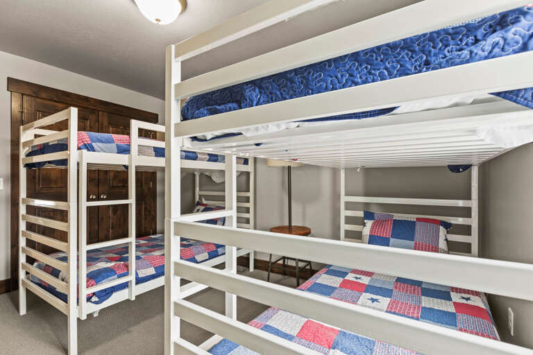 Cozy bunk room with cheerful red, white, and blue bedding, perfect for kids or groups traveling together to create lasting memories.