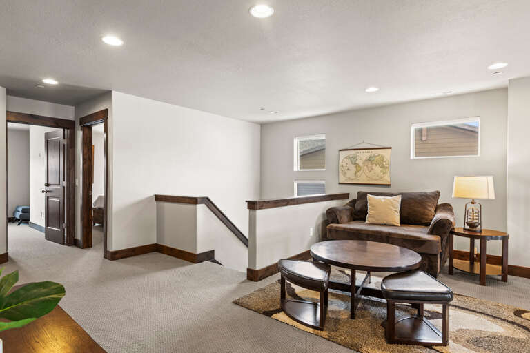 Relax in your private upper-level lounge with rich wood accents, plush seating, and nesting tables—a perfect retreat for morning coffee or evening conversation.