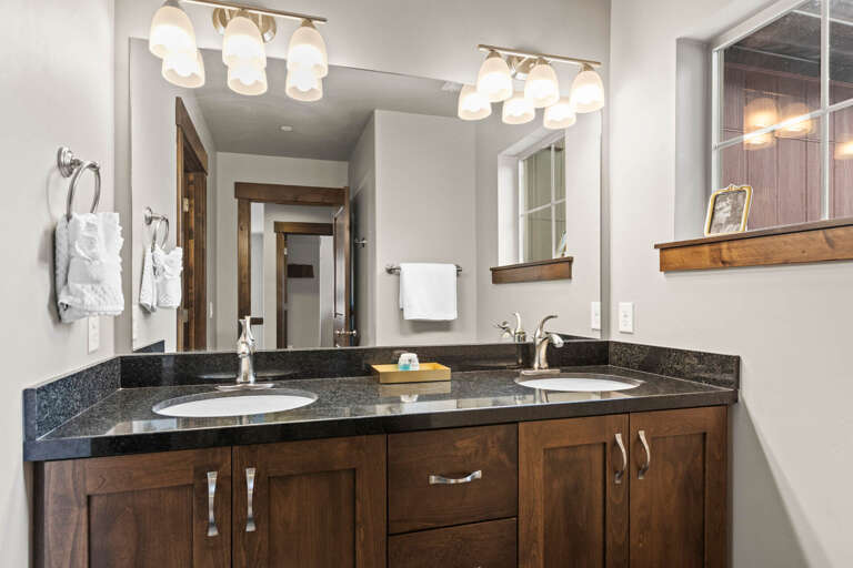 Refresh with your own dual-sink vanity, complete with elegant granite countertops, warm wood cabinetry, and bright mirror lighting to make mornings effortless.