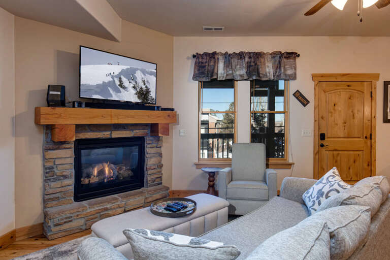 Cozy up by your stone fireplace with mountain views streaming through large windowsâperfect for relaxing after outdoor adventures.