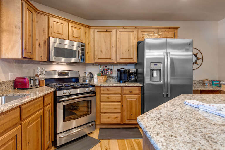 Your fully equipped kitchen features granite counters, stainless appliances, and warm wood cabinets for all your culinary adventures.