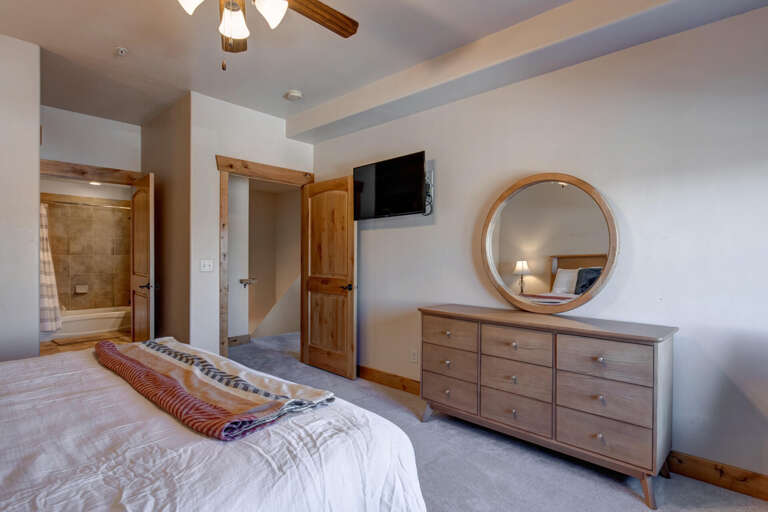 Unwind in your serene bedroom with rustic wood accents, cozy bedding, and modern amenities creating the perfect mountain retreat.
