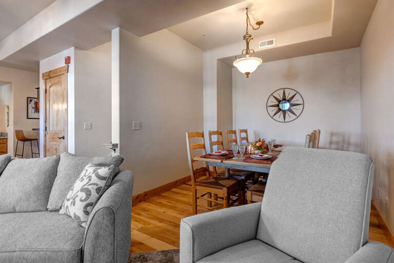 Settle into the comfortable living room where warm wood floors and exposed beams create a cozy atmosphere for your memorable gathering.