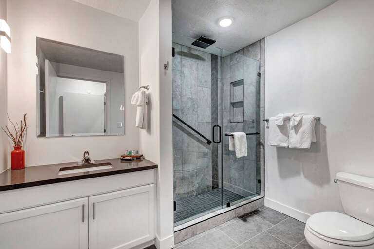 Indulge in your private spa-like bathroom featuring a luxurious glass-enclosed shower and elegant marble tiles for your ultimate relaxation.