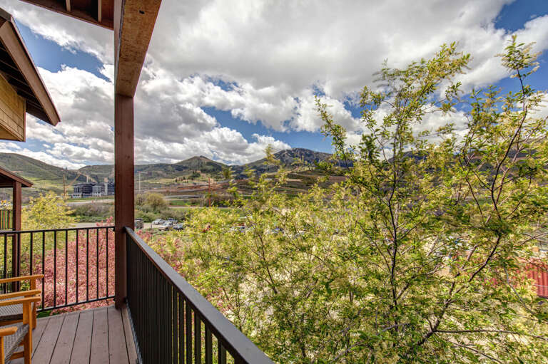 Breathtaking mountain panorama stretches before your private balcony, where morning coffee feels like a retreat into nature's embrace beneath dramatic skies.