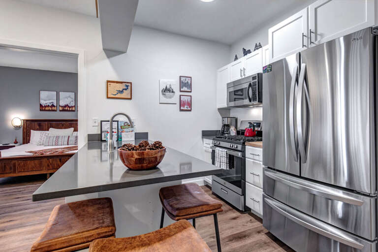 Your sleek modern kitchen features granite countertops, stainless steel appliances, and a breakfast bar perfect for morning coffee or evening snacks.