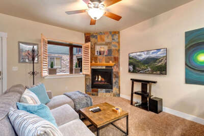 Unwind in this cozy living room where warm fireplace glow meets mountain views. Your perfect retreat features plush seating and inviting ambiance for relaxing evenings.