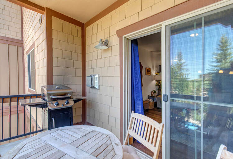 Your private patio with a gas grill and serene views through sliding glass doors—perfect for morning coffee or evening cookouts under the shelter of warm wood and shingles.