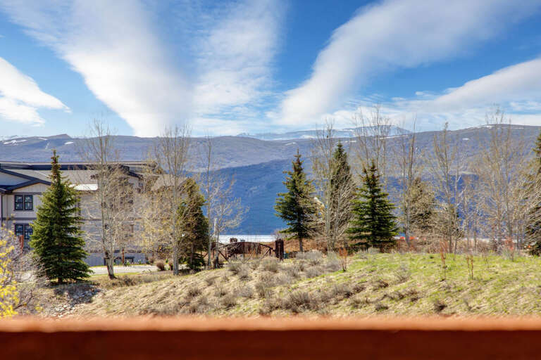 Mountain views framing evergreens and neighboring properties under wide-open skies—a scenic backdrop for your mountain getaway.