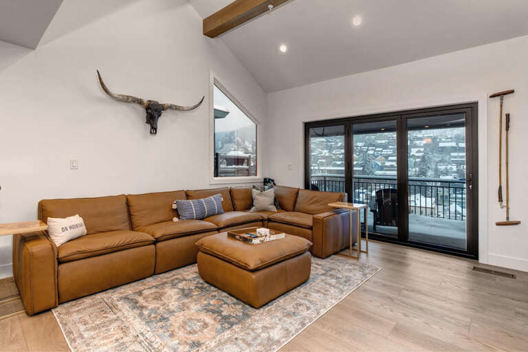 Sink into luxurious leather seating while enjoying stunning mountain views through floor-to-ceiling windows in your cozy living room retreat.