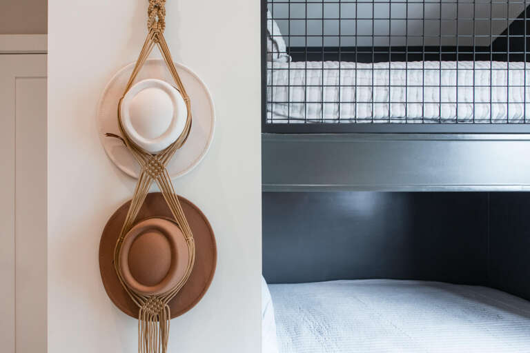 Upper Main 301: Cozy touches await in your bedroom, where thoughtful details like handwoven hat holders create a warm, personalized retreat.