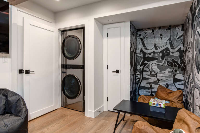 Upper Main 301: Your modern entertainment space features convenient in-unit laundry, striking graffiti art, and cozy seating for relaxing between adventures.