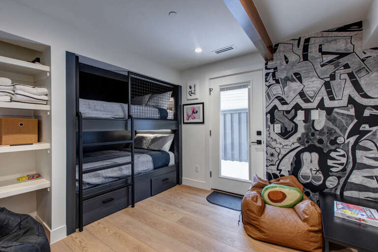 Your kids will love this fun bunk room with bold graffiti-style art and cozy reading nook with built-in storage.