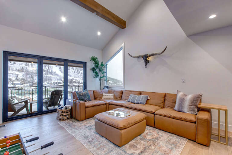 Sink into luxurious leather seating beneath rustic beams, where mountain views through floor-to-ceiling windows create your perfect retreat.