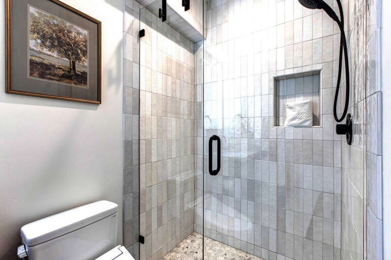 Step into your private spa-like retreat with elegant marble tiles, rainfall shower, and built-in niche for your essentials.