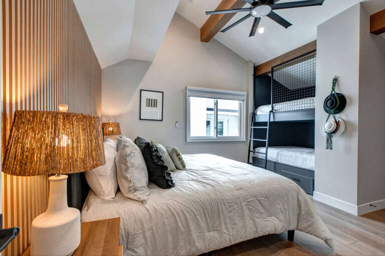 Unwind in this beautifully designed bedroom featuring a cozy main bed and convenient built-in bunk beds, perfect for families or groups.