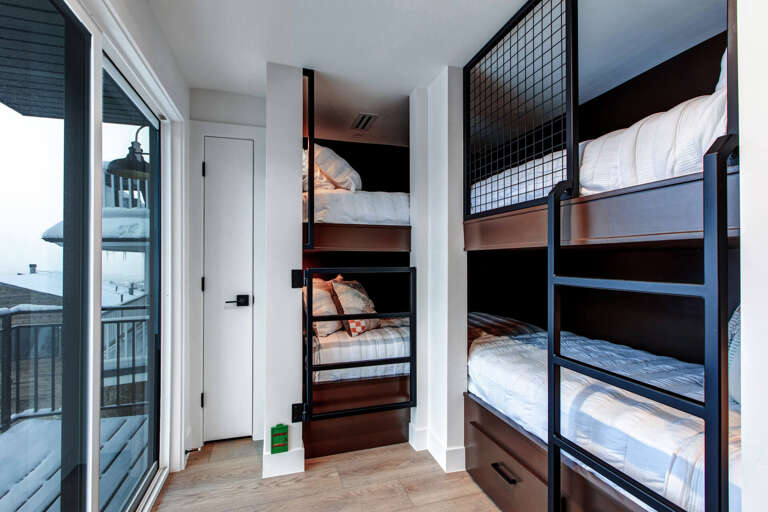 Your private bunk room offers clever modern sleeping quarters with built-in storage and cozy bedding, perfect for families or groups seeking a stylish coastal retreat.