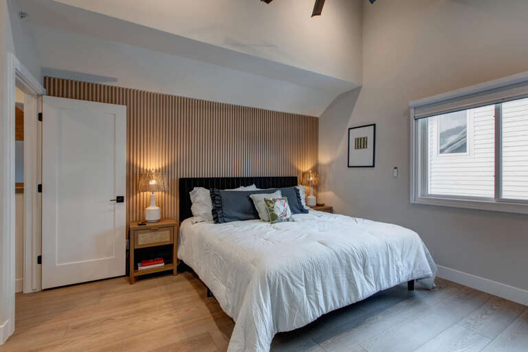 Sink into crisp linens and unwind in this serene bedroom, where warm wood accents and soft lighting create a restful retreat after your day's adventures.