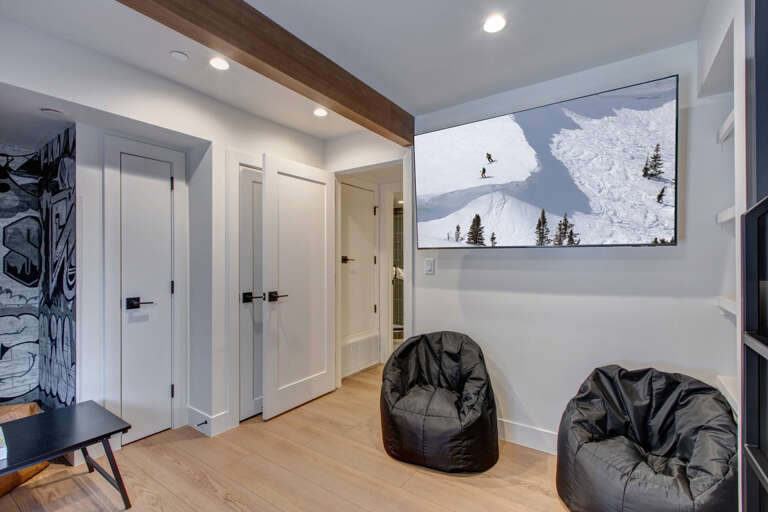 Modern entryway greets you with ski slope artwork and cozy bean bags, blending mountain adventure with comfortable relaxation after your day exploring nearby slopes.