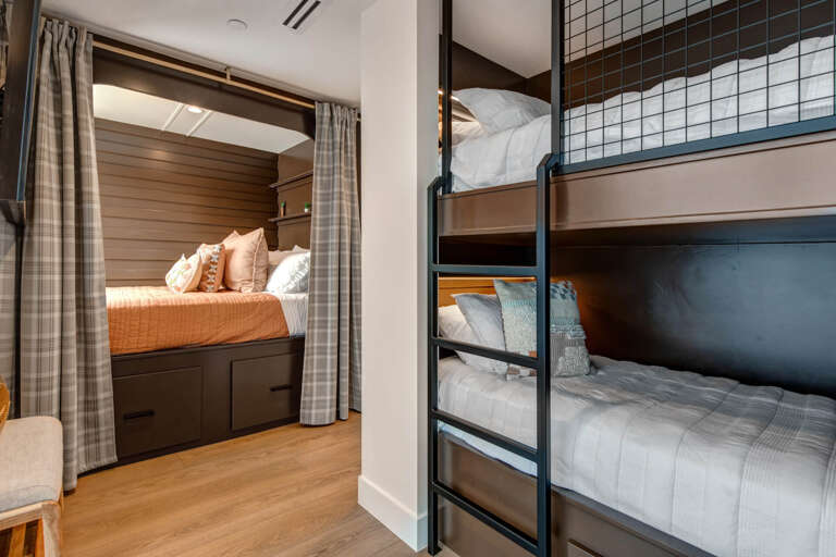 Your cozy retreat features built-in bunk beds with plush linens and a private alcove bed, perfect for families or groups seeking comfort and togetherness.
