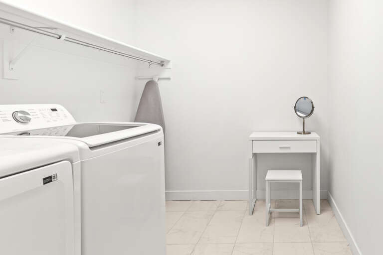 A bright, dedicated laundry space with washer and dryer makes keeping your vacation wardrobe fresh effortless, plus a vanity for your convenience.