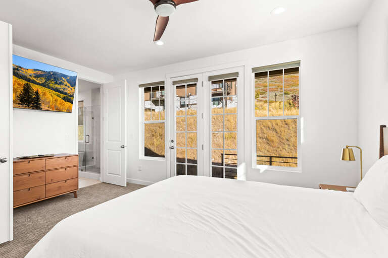 Wake to stunning mountain vistas from your serene bedroom. Step through French doors to your private deck, breathe fresh air, and embrace peaceful moments in this sun-filled sanctuary.