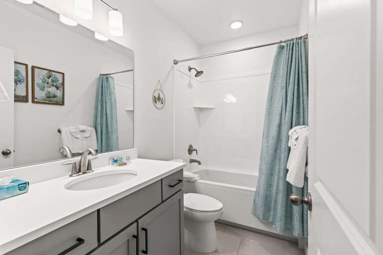 Your private bathroom features a sleek vanity, refreshing shower-tub combo, and calming teal accents that invite relaxation after a day of adventure.