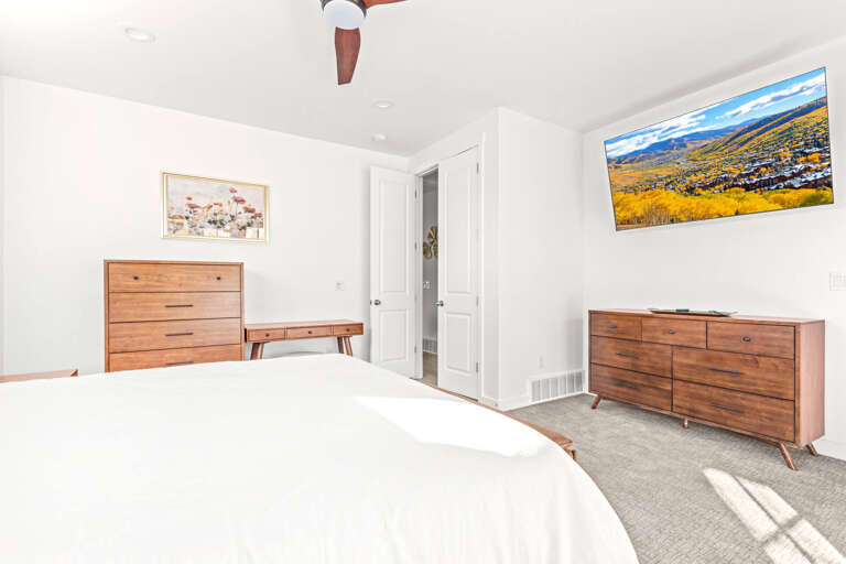 Drift off in your serene bedroom, where warm wood tones and crisp linens invite restful sleep, with mountain views framed on the wall to inspire your next adventure.