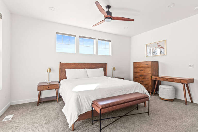 Jordanelle Ridge 499: The primary master suite is located upstairs and includes a king-sized bed, 2 bedside tables, a bench, dresser, and a chest.
