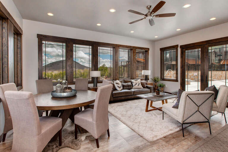 Settle into this bright, open-concept space where your mornings begin at the dining table and evenings unwind on plush seating—all framed by stunning mountain views through expansive windows.