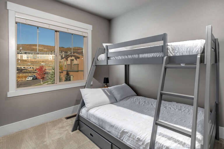 Comfortable bunk beds with crisp linens invite restful nights, while large windows frame neighborhood views and fill your room with natural light.