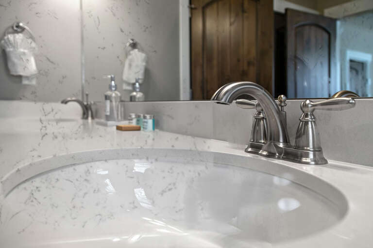 Freshly laundered towels and upscale marble countertops set the stage for your refreshing morning routine in this elegant bathroom.