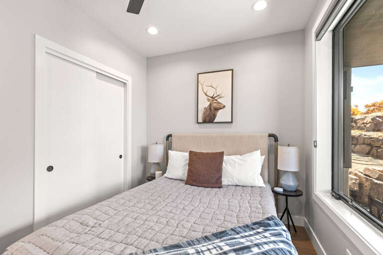 Slip into crisp linens and unwind in your tranquil bedroom, where mountain views through the sliding door and charming decor invite peaceful rest.