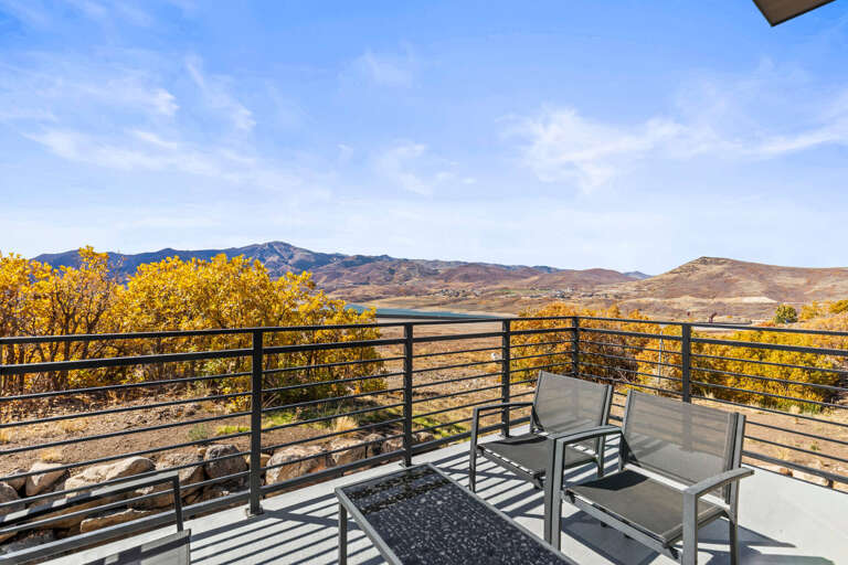 Relax on your private balcony with sweeping mountain and lake views, golden foliage framing the serene landscape—a peaceful escape awaits.