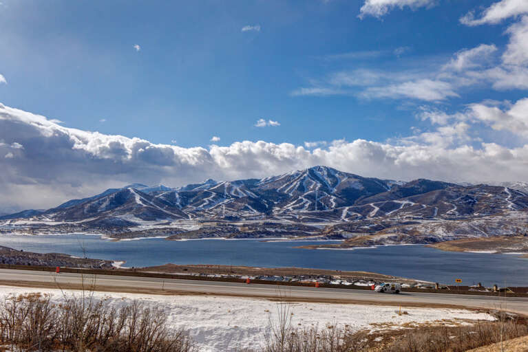 Stunning winter panorama showcasing snow-dusted mountains, a tranquil reservoir, and nearby ski slopes—a scenic backdrop to the property's surrounding area.