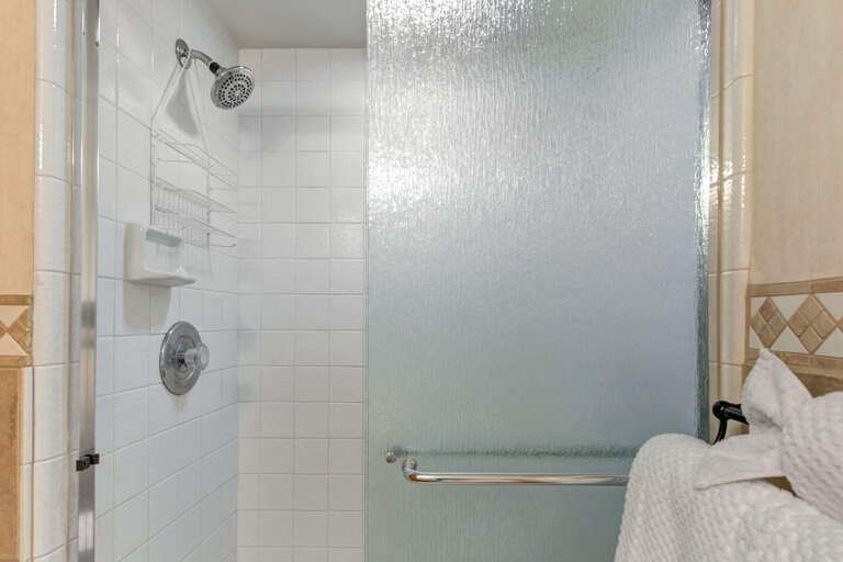 Step into your private shower with a rainfall showerhead and grab bar for safety. Fresh towels await you after a refreshing rinse.