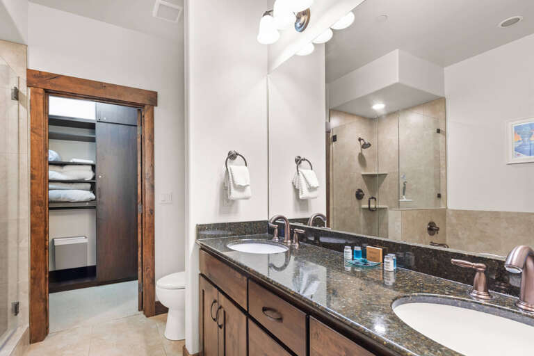 Luxurious granite vanity with dual sinks awaits your morning routine, while your spacious walk-in shower promises relaxing evenings.
