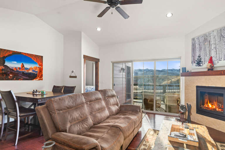 Unwind in your cozy living room with mountain views, crackling fireplace, and plush leather seating perfect for evening relaxation.