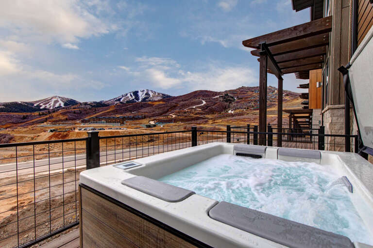 Soak in bubbling warmth while mountain peaks frame your perfect retreat moment.